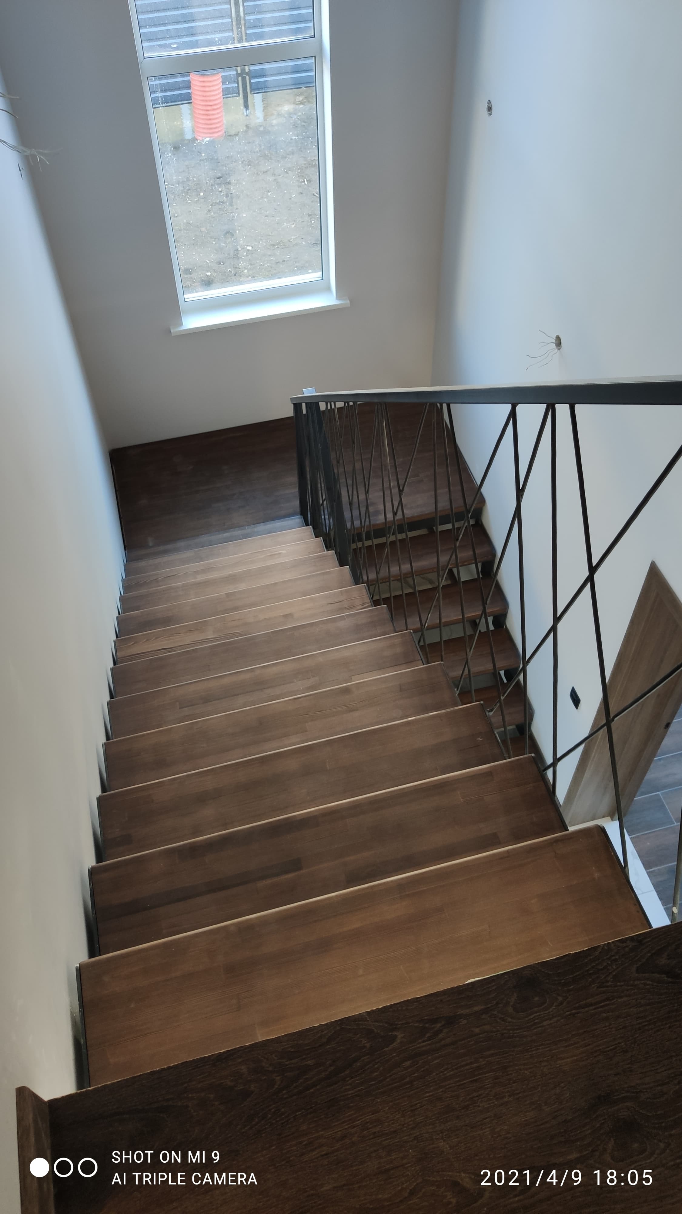 Деревянная лестница с кованым металлическим ограждением